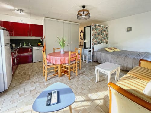 Studio à Digne-les-Bains avec cuisine rouge, coin repas, lit et espace de vie