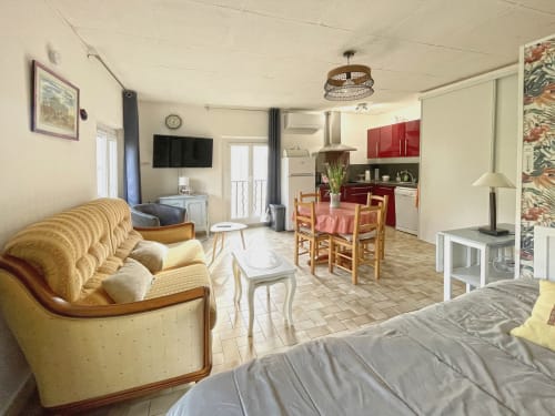 Studio MISTRAL à Digne-les-Bains avec séjour, cuisine rouge, canapé-lit et table à manger
