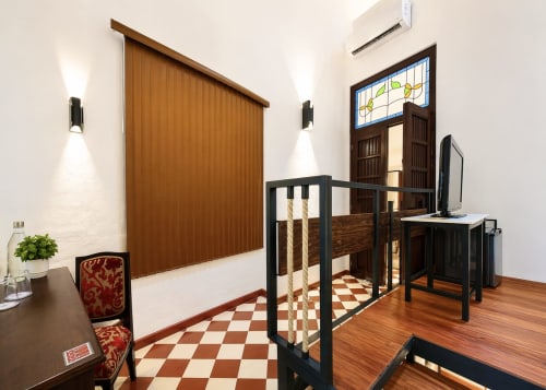 Villa Merida Boutique Hotel room entrance with wooden door, desk, staircase and checkered floor in Merida