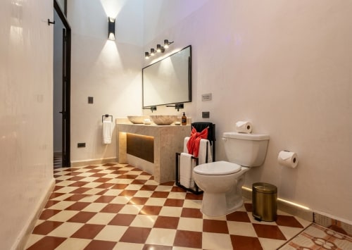 Modern bathroom at Villa Merida Boutique Hotel with diamond-patterned floor, vessel sink, and mirror lighting in Merida