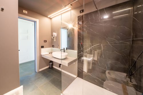 Bagno moderno della Resort Hotel Belvedere con doccia in marmo, lavabo sospeso e rubinetteria di design