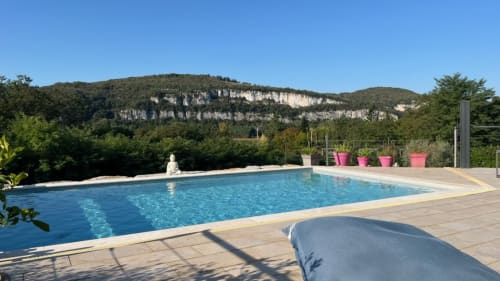 Piscine avec falaises calcaires en arrière-plan au Gite la Villa des Falaises du Lot, Tour de Faure