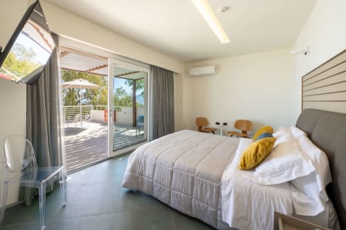 Junior Suite all'Hotel Belvedere Resort con vista mare, balcone con piscina a sfioro, letto moderno e porte-finestre sulla terrazza