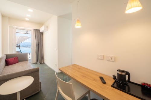 Junior Suite con scrivania in legno, balcone con vista mare e piscina a sfioro presso l'Hotel Belvedere Resort, Castellammare del Golfo