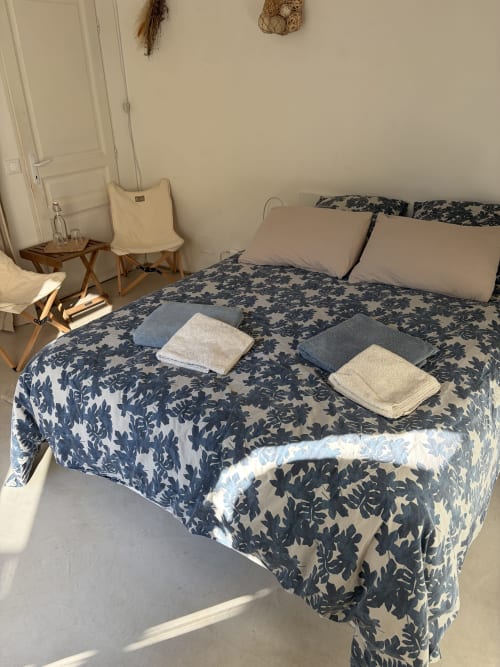 Chambre douillette à Le Patio aux Oiseaux B&B à La Ciotat avec literie florale marine et serviettes pliées