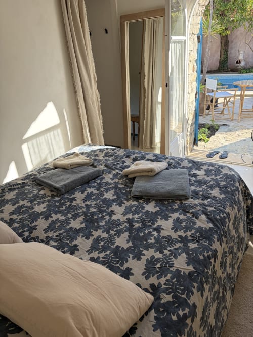 Chambre Le Chardonneret au Patio aux Oiseaux B&B à La Ciotat : lit aux motifs, serviettes fraîches et accès à la vue sur la piscine
