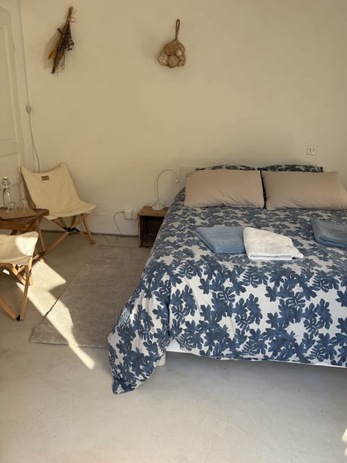 Chambre Le Chardonneret au Patio aux Oiseaux à La Ciotat, avec literie florale bleu marine et mobilier crème