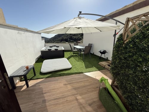 Terrazza panoramica con vista mare a Sardinia Holidays, lettini, jacuzzi, ombrellone sospeso e lussureggiante vegetazione a Torpè