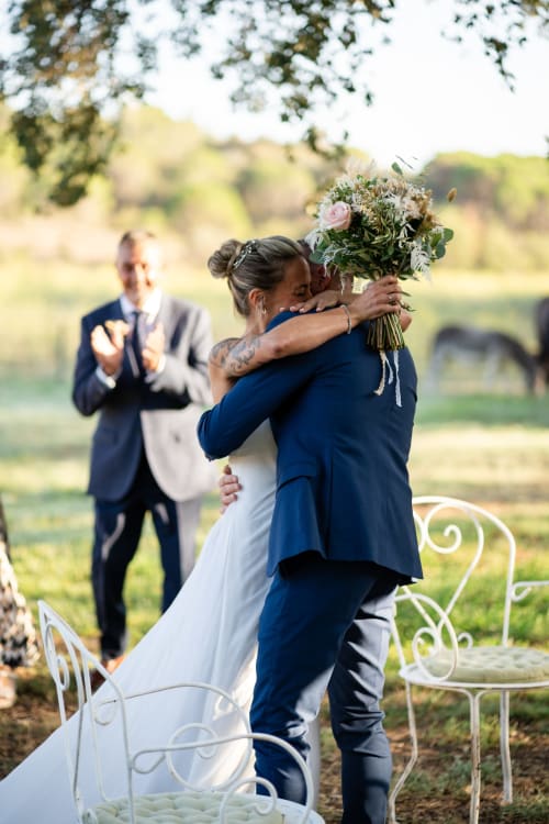 Bride and groom embrace at outdoor wedding ceremony in rural Rabós, Spain