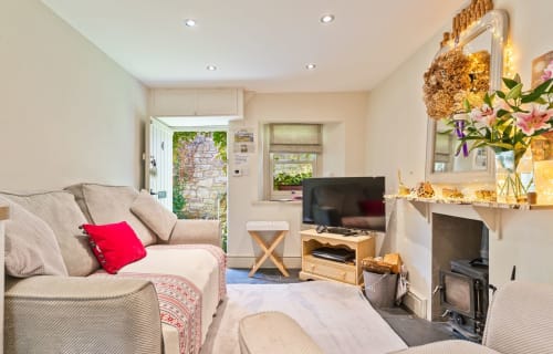 Cosy Llangattock Hideaway cottage living room with seating area, fireplace, TV, and mountain views in Crickhowell