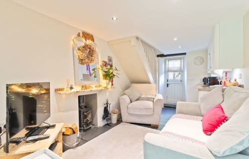 Cozy cottage bedroom with fireplace, sitting area, and mountain views at Cosy Llangattock Hideaway in Crickhowell