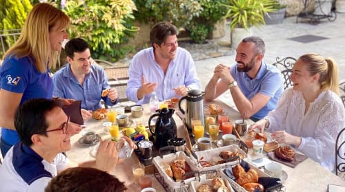 Les clients savourent le petit-déjeuner ensemble à Le Clos Des Anges, à Bagnols, en France, assis en plein air avec viennoiseries et jus de fruit