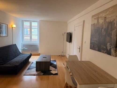 Appartement 1 chambre moderne à l'Hôtel Saint Christophe Belfort avec salon, canapé noir, parquet et vue sur la ville