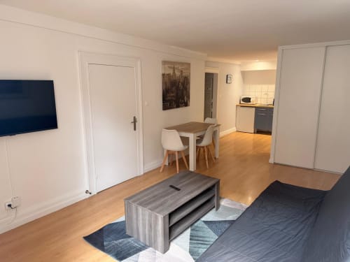 Chambre moderne avec coin salon, table à manger et kitchenette équipée à l'Hôtel Saint Christophe de Belfort