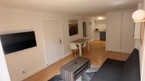 Appartement moderne ouvert à l'Hôtel Saint Christophe Belfort avec séjour, salle à manger, cuisine et TV murale