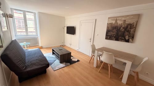 Appartement 1 chambre moderne à l'Hôtel Saint Christophe à Belfort avec salon, canapé noir, parquet et vue sur la ville