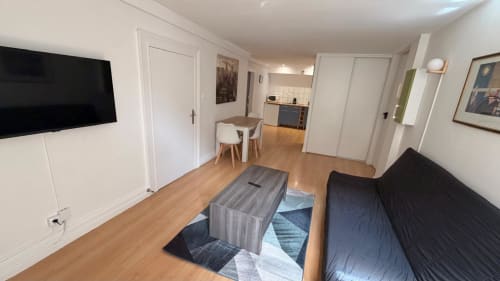 Studio moderne à l'Hôtel Saint Christophe Belfort avec espace de vie, canapé, TV, table à manger et kitchenette