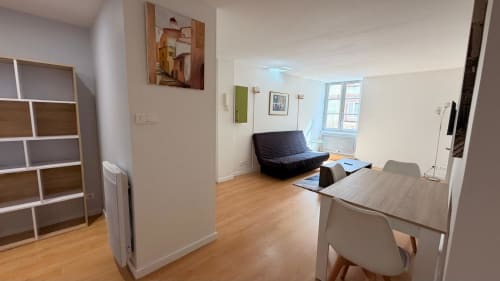 Appartement 1 chambre moderne à l'Hôtel Saint Christophe Belfort avec séjour, table à manger, canapé noir et parquet