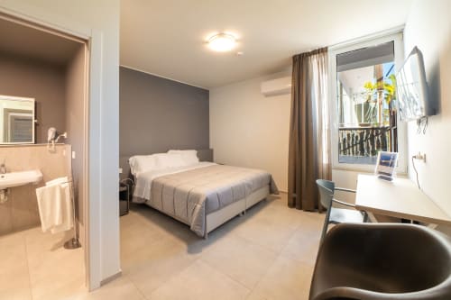 Camera confortevole del Belvedere Resort a Castellammare del Golfo con letto matrimoniale, area di lavoro, bagno e vista sulle montagne