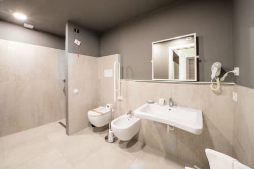 Bagno moderno del Resort Hotel Belvedere con doccia walk-in, wc, bidet e lavabo con specchio