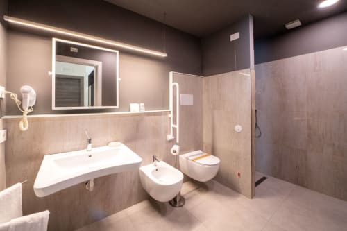 Bagno moderno e accessibile all'Hotel Belvedere Resort con lavabo, bidet, wc e doccia walk-in