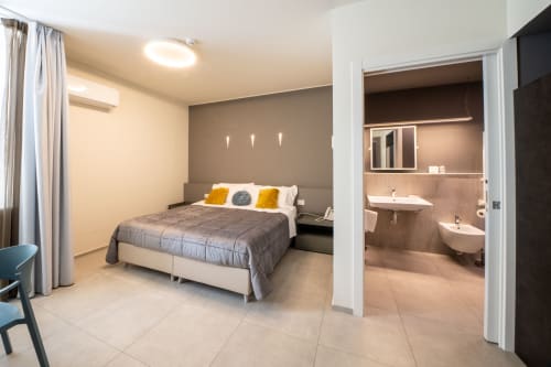 Camera moderna e accessibile presso l'Hotel Belvedere Resort con letto matrimoniale, bagno privato e arredi contemporanei