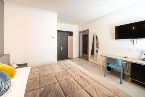 Camera accessibile presso l'Hotel Belvedere Resort con letto, TV a schermo piatto, scrivania e arredi moderni a Castellammare