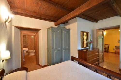 Camera dell'Appartamento Il Tiglio Superior presso l'Agriturismo Buriano a Lubriano, con travi in legno e vista sul giardino