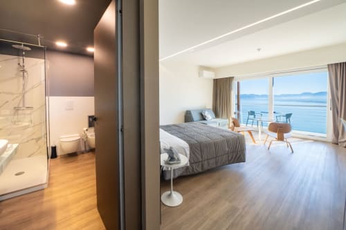 Suite di lusso con vista mare presso Hotel Belvedere Resort, camera da letto moderna, bagno privato e balcone panoramico con vista costiera