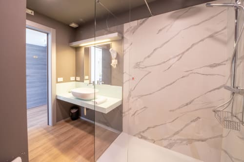 Moderno bagno con doccia in marmo, lavabo d'appoggio e specchio della vanity all'Hotel Belvedere Resort di Castellammare del Golfo