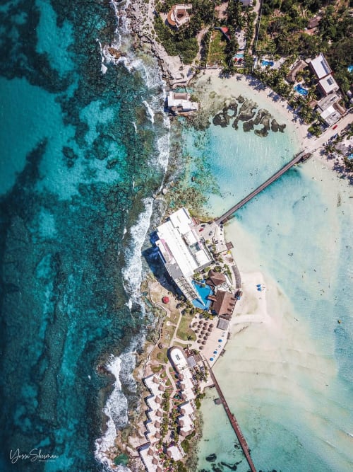 Aerial view of Malkita Homes beachfront resort with turquoise waters, white buildings, and pristine sandy beach in Highland