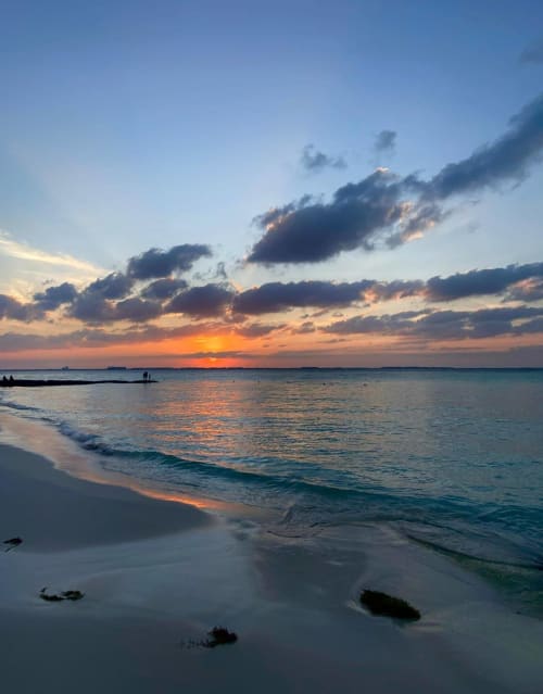 Sunset beach scene with golden sky, waves, and clouds at Malkita Homes Highland Mills