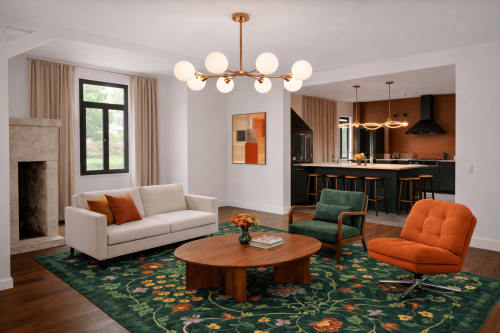 Salon ouvert contemporain à la Maison 1903 B&B avec canapé crème, fauteuil orange, table en bois, tapis fleuri vert et laiton