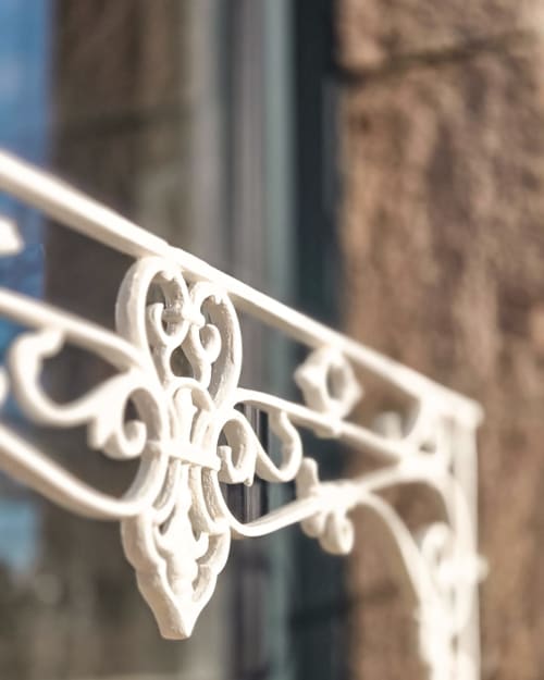 Ornements en fer forgé blanc élégant à la rampe de La Maison 1903 B&B à Trévou-Tréguignec, France
