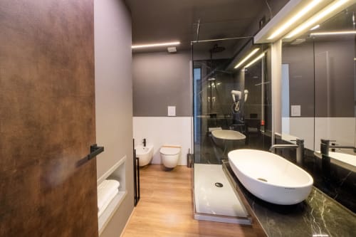 Bagno moderno nella Suite Premium dell'Hotel Belvedere Resort con lavabo ovale bianco, doccia walk-in, specchio riscaldato ed elegante