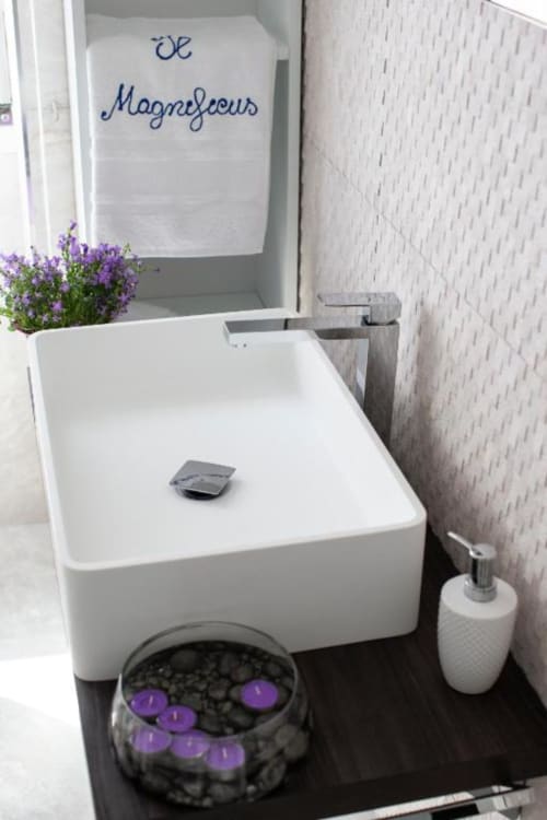 Vasca da bagno bianca moderna nel bagno della Junior Family Suite di Domus Gaudia Roma, decorata con candele viola e fiori