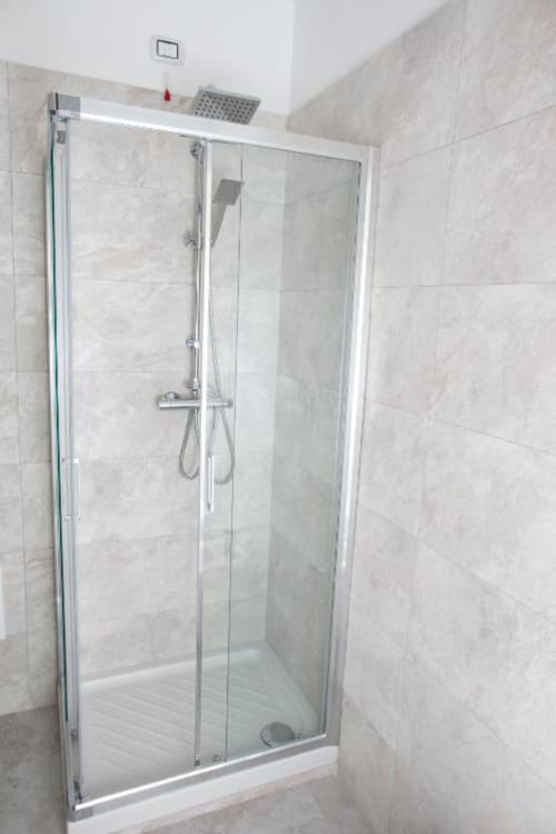 Moderna cabina doccia in vetro con soffione pioggia nella stanza da bagno della Junior Family Suite all'Exclusive Domus Gaudia, Roma