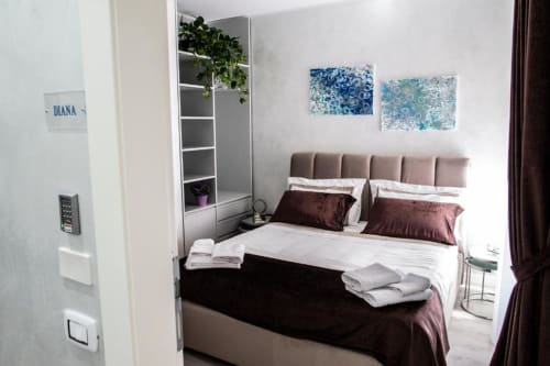 Camera Deluxe con letto King al boutique hotel Exclusive Domus Gaudia di Roma, con testiera marrone e biancheria bianca