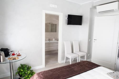 Superior King Room at Exclusive Domus Gaudia in Rome, featuring modern furnishings, wall-mounted TV, and bathroom access