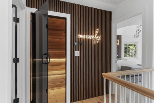 Malkita Homes spa area with sauna, neon 'Time to Relax' sign, and staircase in Highland Mills