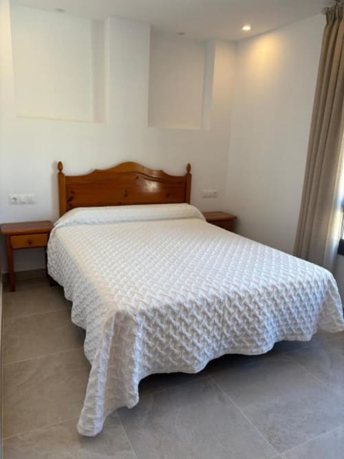 Acogedor dormitorio doble en Hotel Mulhacén Trevélez con cama de madera, ropa blanca y modernas comodidades en Granada