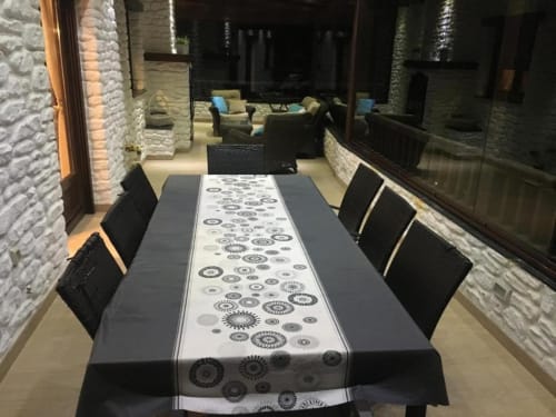 Modern dining terrace at Hotel Mulhacén Trevélez with black chairs, patterned table runner, and white brick walls.