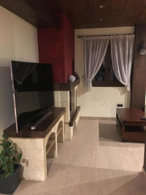 Modern hotel suite at Hotel Mulhacén with TV, cream furnishings, and draped windows in Trevélez