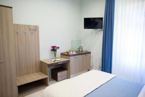 Suite Executive moderna di Exclusive Domus Gaudia a Roma, con arredi in legno, TV schermo piatto, angolo cottura