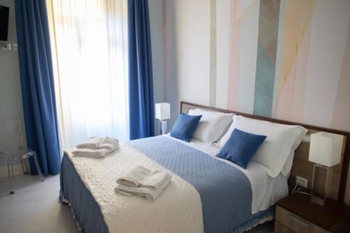 Camera Executive Suite presso Domus Gaudia Roma con biancheria blu, vista sulla città e servizi moderni