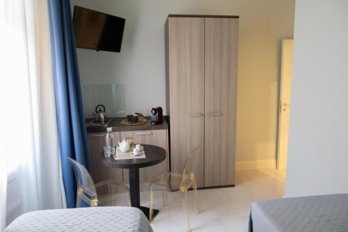 Moderna camera studio presso Exclusive Domus Gaudia a Roma con angolo cottura, zona pranzo e TV a schermo piatto con vista sulla città