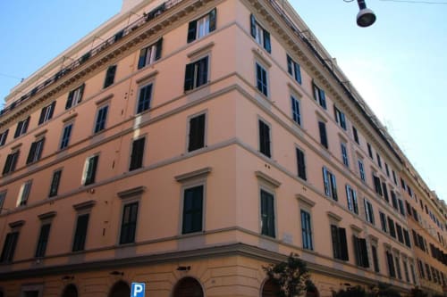 Elegante facciata storica color pesca a Roma con finestre ad arco e architettura classica, Esclusiva Domus Gaudia