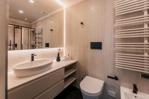 Bagno moderno della villa esclusiva Domus Gaudia a Roma con lavabo ovale, scaldasalviette e elegante toilette nera