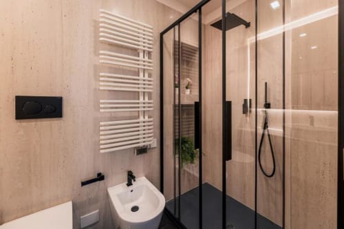 Bagno moderno all'Exclusive Domus Gaudia Roma con box doccia a cornice nera, lavabo bianco e scaldasalviette