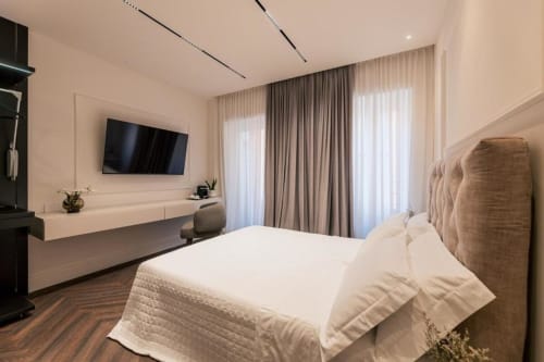 Lussuosa camera da letto a Domus Gaudia Roma con letto matrimoniale, TV a schermo piatto e accesso al balcone con tende